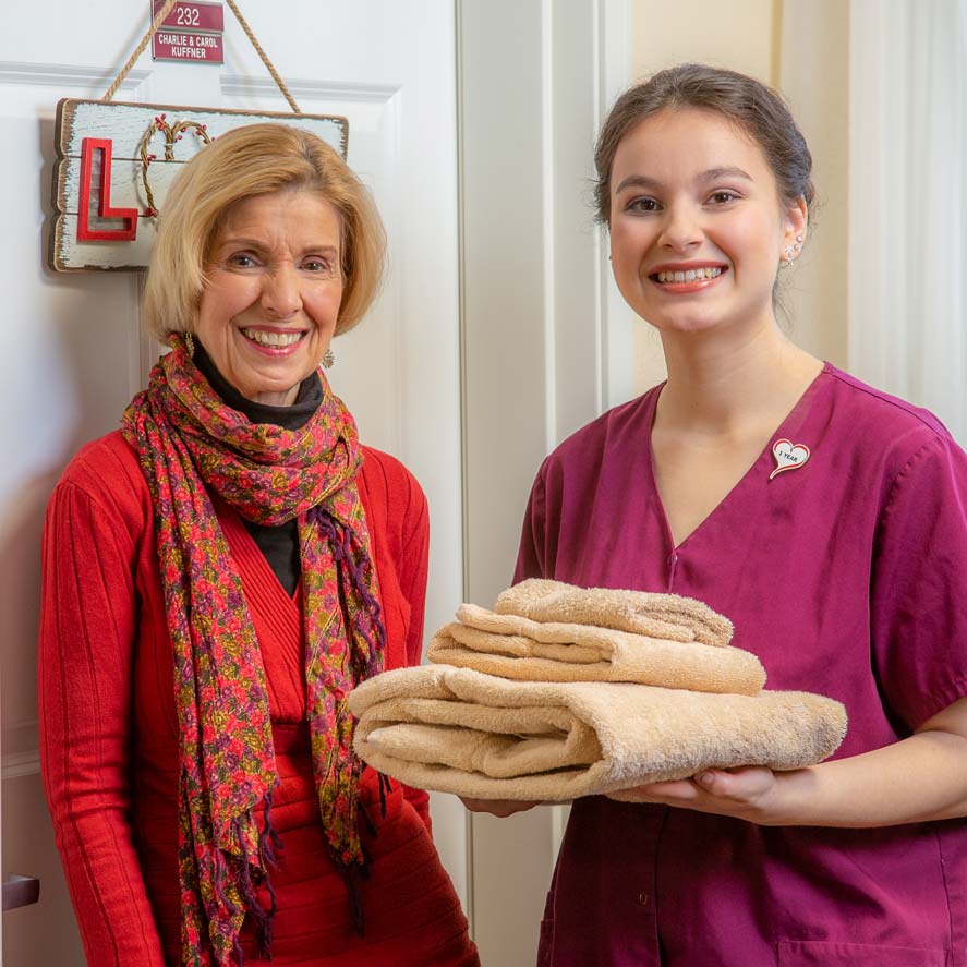 A team member delivering fresh linens to a resident at Mulligan Park